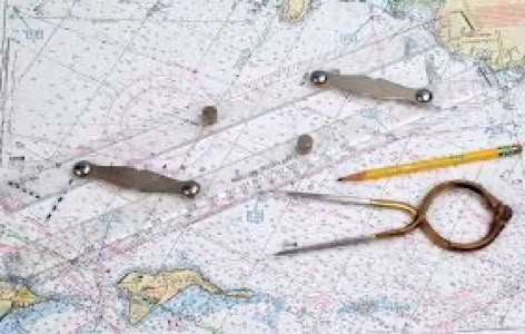 A nautical chart with a parallel ruler, a pencil, and a pair of dividers placed on top.
