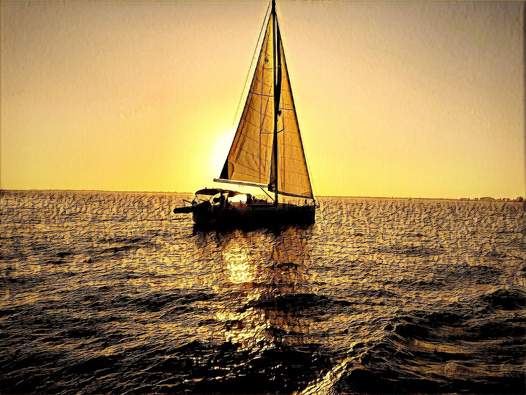 A sailboat on the water with the sun setting in the background, casting a golden glow.