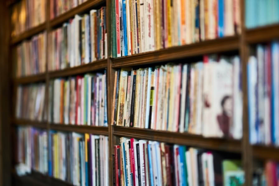 A bookshelf filled with various books arranged vertically.